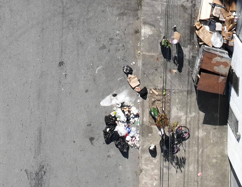 Person standing next to illegal dumpsite — completely unidentifiable from drone altitude